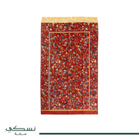 Tapis de prière Nusuki Al-Rawda vert et rouge avec motifs traditionnels, prêt à être utilisé pour la prière.