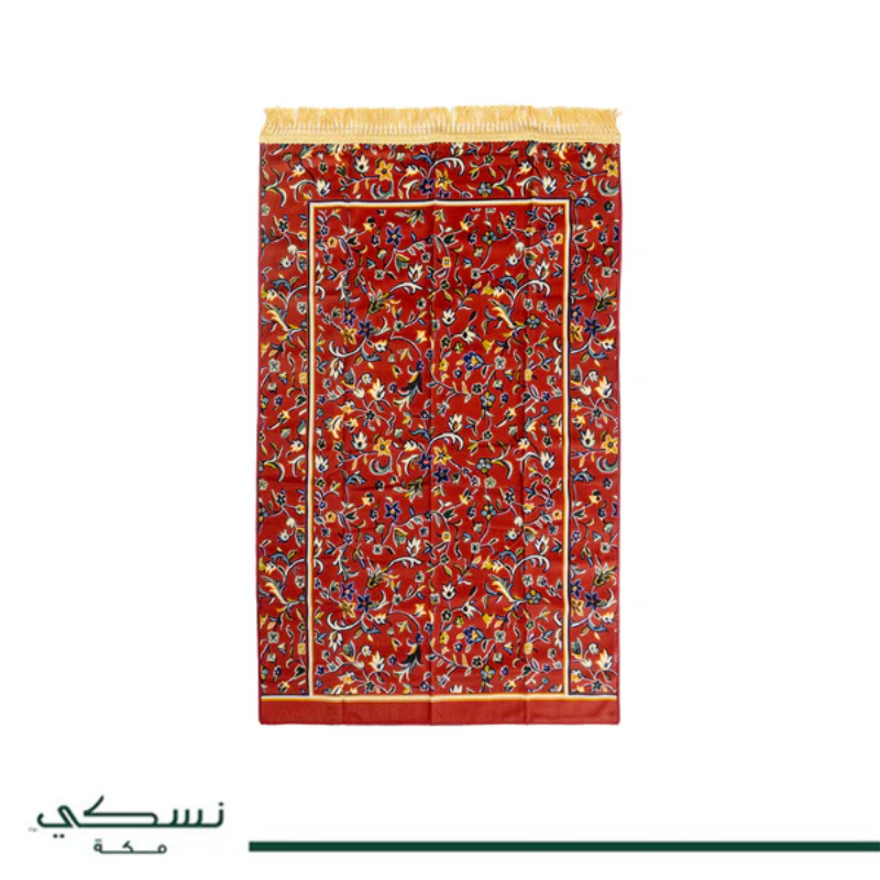 Tapis de prière Nusuki Al-Rawda vert et rouge avec motifs traditionnels, prêt à être utilisé pour la prière.