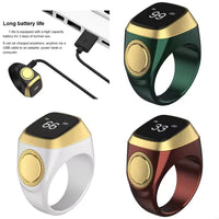 Bague Tasbih connectée Iqibla, compteur dhikr électronique élégant, en métal argenté avec écran digital, portée sur un doigt.