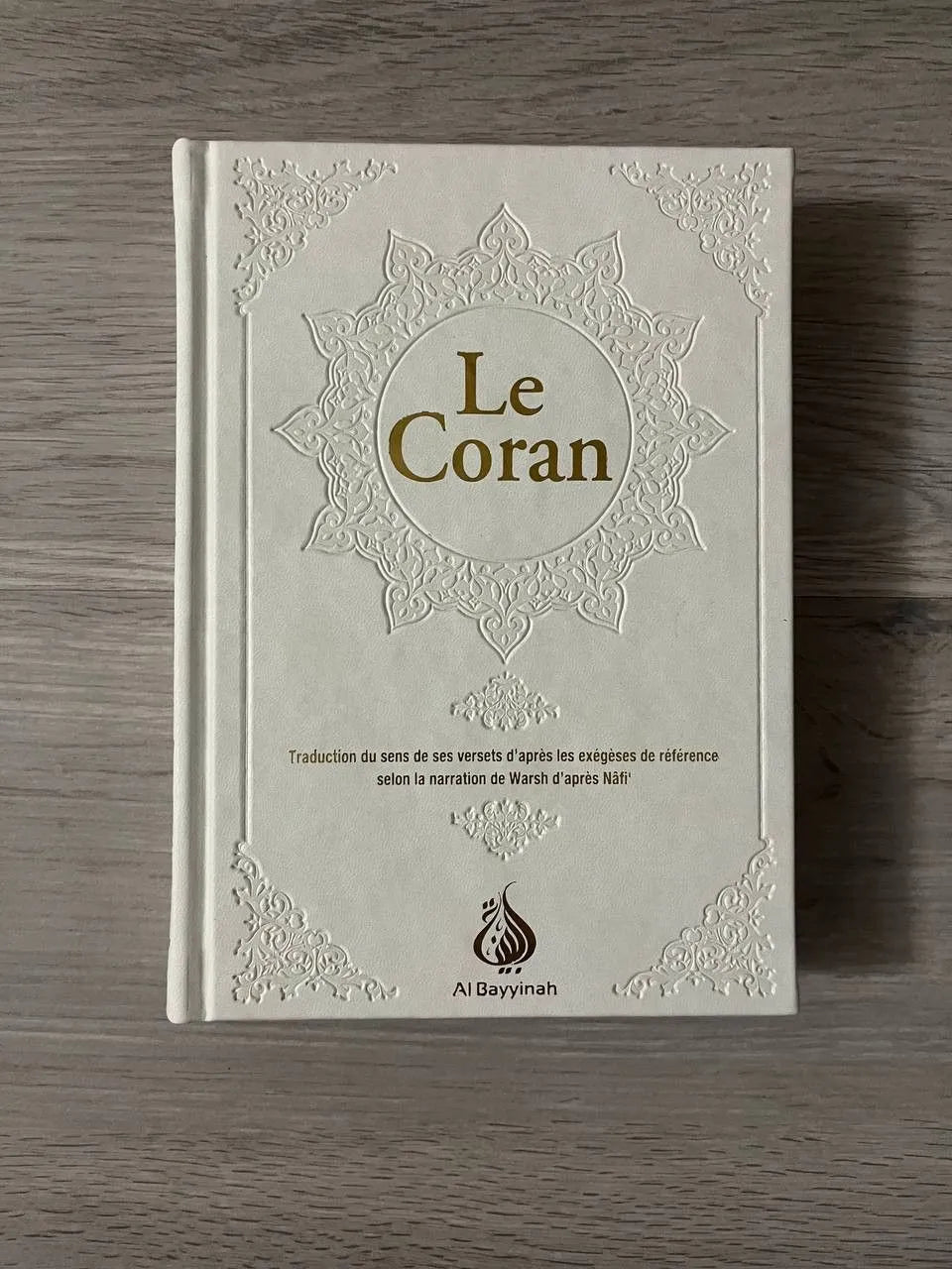 Coran en arabe et français, édition Al Bayyinah, traduction par Rachid Maach, livre blanc avec texte religieux.