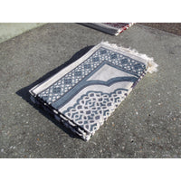 Tapis de prière Sana Edition avec motif géométrique bleu ardoise sur fond blanc, vue de face.