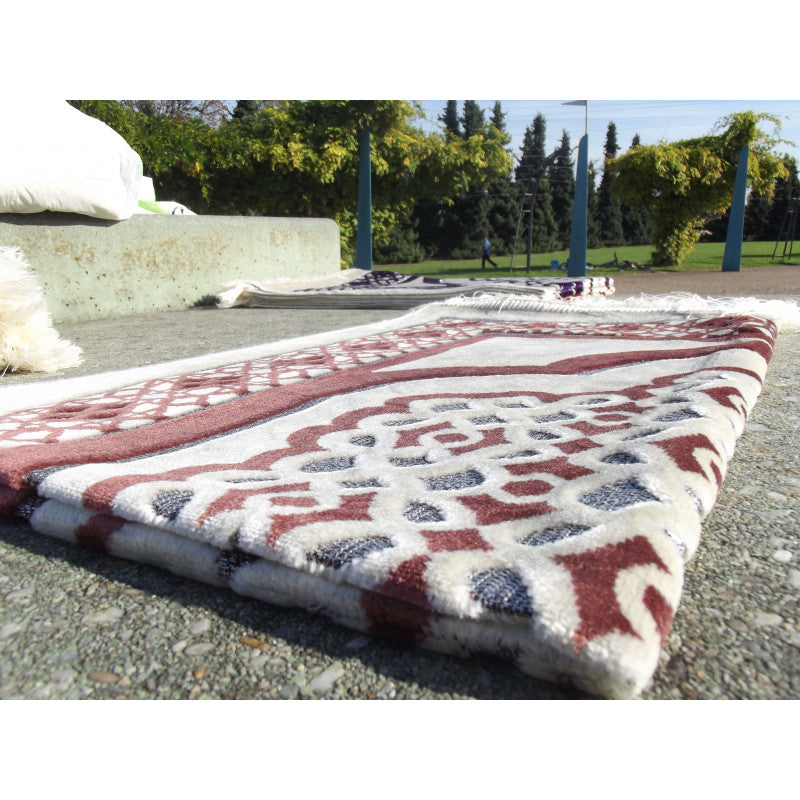 Tapis de prière Sana Edition avec contour géométrique en couleur terracotta sur fond blanc, design élégant et moderne.