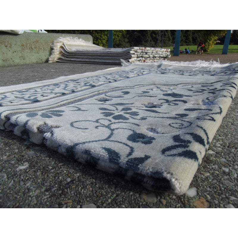Tapis de prière Sana Edition avec motif jardin bleu ardoise sur fond blanc, design élégant et confortable pour la prière.
