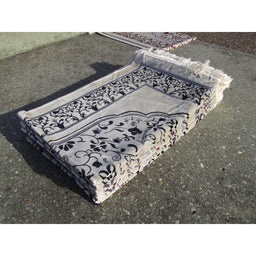 Tapis de prière Sana Edition avec motif jardin, fond blanc et couleur bleu marine, visible avec détails du design floral.