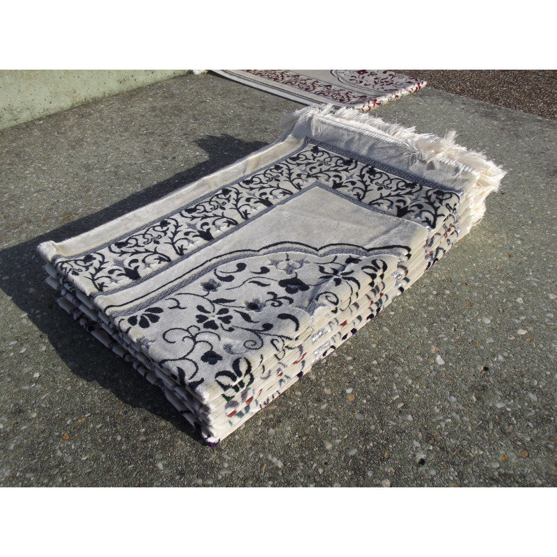 Tapis de prière Sana Edition avec motif jardin, fond blanc et couleur bleu marine, visible avec détails du design floral.