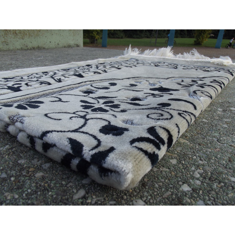 Tapis de prière Sana Edition avec motif jardin bleu marine, fond blanc, pour la pratique religieuse, vue de face.