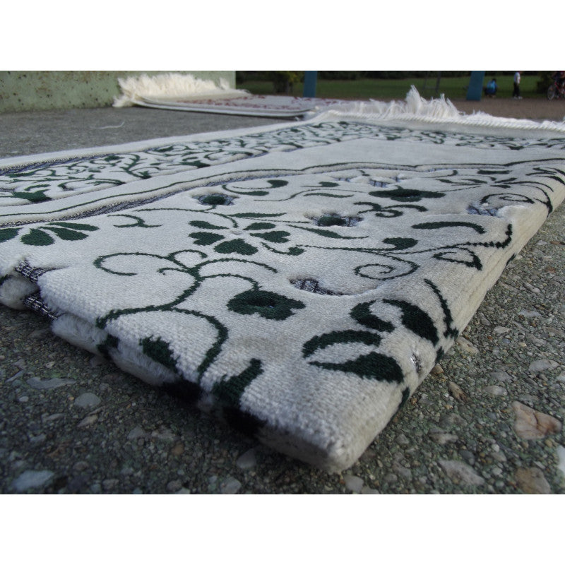 Tapis de prière Sana Edition avec motif jardin vert sur fond blanc, élégant et confortable pour la prière.