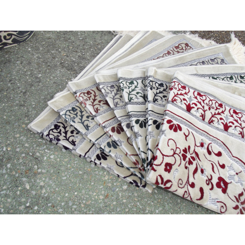 Tapis de prière Sana Edition avec motif de jardin, fond blanc et détails en vert, image montrant le design élégant et coloré.